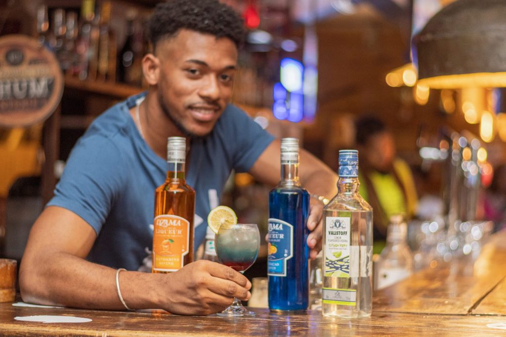 Homme devant des boissons colorées